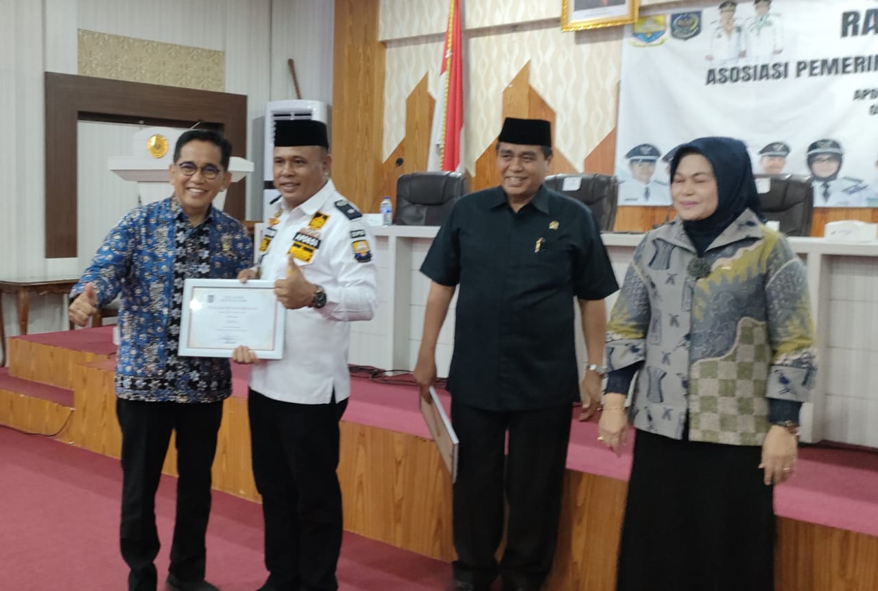 Anggota Komisi V DPR RI H Bakri (Batik Biru) Menerima Penghargaan dari Ketua Apdesi Provinsi Jambi (Daus/Zabak.id)